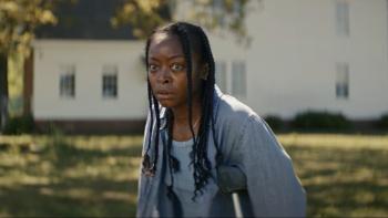 The Woman in the Yard Movie: On crutches, Ramona (Danielle Deadwyler) stands in her front yard, a worried look on her face