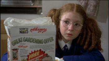 Wombling Free: A young White school girl with red hair sits at the dinner table