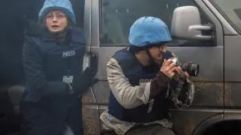 Words of War: Maxine Peake wears a protective army helmet as she steps out of a vehicle, a fellow member of the press holding a camera in front of her