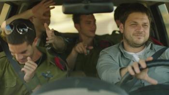 Yossi: Ohad Knoller smiles as he drives a car full of young soldiers
