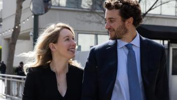 You Can See Everything movie: Theranos founder Elizabeth Holmes and partner Billy Evans smile at each other while walking down a street
