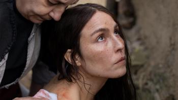 You Won't Be Alone: Close-up of Noomi Rapace looking up to sky with older woman behind her