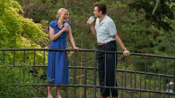 Young Werther movie: Allison Pill laughs with Douglas Booth as they stand atop a bridge surrounded by green trees