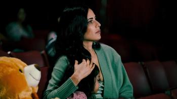 Merry Christmas: Maria hugs her daughter as she looks to the sky with a large teddy bear next to them