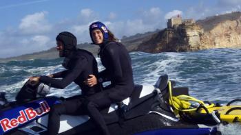 100 Foot Wave TV show screenshot 2: getting ready to tow a surfer to the top of a wave on a jet ski