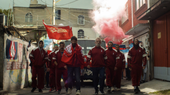 90 Minutes TV show screenshot 2: Las Navajas walk together in red uniform with red smoke behind them.