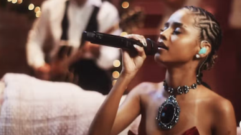 A Nonsense Christmas with Sabrina Carpenter screenshot 2: Tyla holds microphone and sings. 