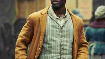 Stephen Graham and Malachi Kirby throw punches at each other in a boxing ring. Graham wears red pants, while Kirby wears brown.