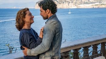 Deceitful Love TV show screenshot: A White man and a White woman embrace while looking into each other's eyes by an ocean harbor