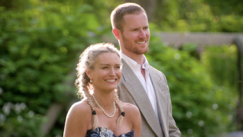 Age of Attraction TV show screenshot 3: A woman in flower dress stands next to taller man in tan suit. 