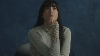 Aitana: Metamorphosis screenshot 1: Aitana sits with chin in hand. 