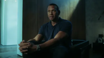Alex vs ARod TV show screenshot 1: Alex Rodriguez in dark shirt sitting in dark chair in dim light