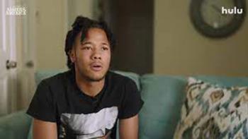 Algiers America: The Relentless Pursuit: A young Black man sits on a couch.