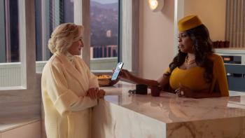 Glenn Close and Niecy Nash-Betts across from each other. Close wears a white outfit, Nash-Betts wears a mustard yellow outfit.