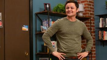 Alternatino with Arturo Castro TV Series: Arturo stands in a living room with exposed brick, arms akimbo