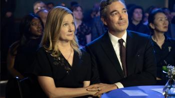 American Classic TV show screenshot 3: Laura Linney and Jon Tenney sit in an audience. Linney wears a black dress, Tenney wears a black suit jacket.