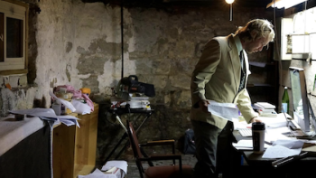 American Conspiracy: The Octopus Files TV show screenshot 2: Christian Hansen stands over desk looking at papers.