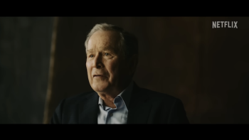 George W. Bush pictured from the shoulders up, with a dark backdrop