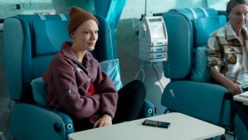 Apple Cider Vinegar TV show screenshot 1: Lucy, wan and bald, is shown in a doctor's office with a bag of chemotherapy chemicals draining into her arm