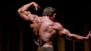 Arnold TV show screenshot: Arnold Schwarzengger is shown from the back posing during his bodybuilding days.