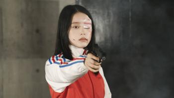 Baby Assassins Everyday!: Chisato aims a gun at an off-screen target. Her left eye is bandaged, and blood splatters her face.