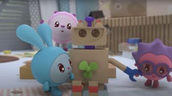 Baby Riki: Two characters play with a cardboard robot toy in a bright nursery room with wooden fence background.
