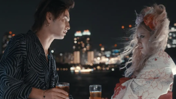 Badly in Love TV show screenshot 3: A male participant talks to female participant at night overlooking skyline. 