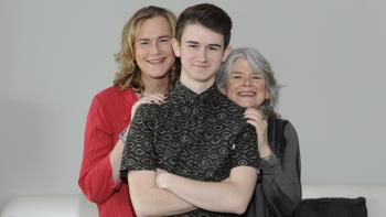 Becoming Us: Family photo with Ben standing in front of two adults, his arms crossed