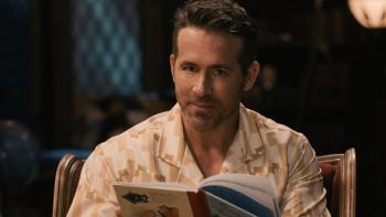 Bedtime Stories With Ryan TV show screenshot 1: Medium shot of Ryan Reynolds holding a book and staring at the camera.