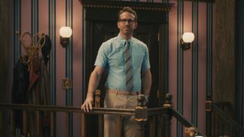 Bedtime Stories With Ryan TV show screenshot 2: Ryan Reynolds walks through the door wearing business clothes with a tie and glasses.
