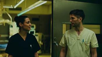 Berlin ER TV show screenshot: two doctors, a White man and a darker-skinned woman look at each other