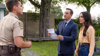 Best Medicine TV show screenshot 2: A police officer confronts Dr. Martin and Louisa in a park; Dr. Martin holds a paper defensively