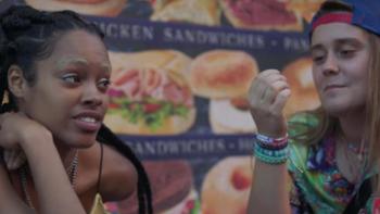 Betty TV show: Two teens, one wearing a backwards ball cap, talk in front of a bodega