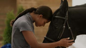 Beyond Black Beauty TV: Black teen wearing a ponytail and grey shirt holds black horse face and touches their foreheads lovingly.