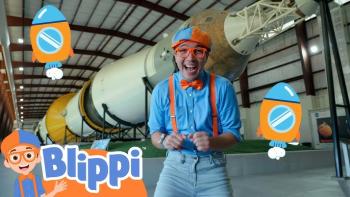 Blippi's NASA Astronaut Adventure TV: Blippi stands in front of a rocket launcher, smiling excitedly at the camera.