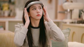 Boyfriend on Demand TV show screenshot 1: Kim Jisoo puts on a silver VR headset. She wears a beige and black striped shirt and a beige hoodie.