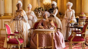Bridgerton Season 1 TV show screenshot 3: Queen Charlotte is at the center of this show, dressed in a pink gown; four ladies in waiting flank her
