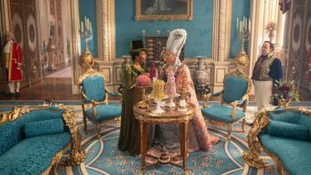 Bridgerton Season 4 TV show screenshot 1: Queen Charlotte stands in front of a table full of bonbons in a room with Brimsley and Lady Danbury