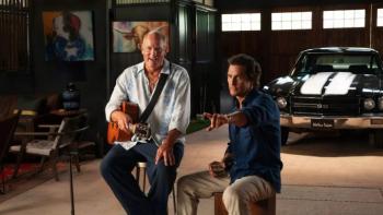 Brothers TV show screenshot 2: Woody Harrelson strums a guitar as Matthew McConaughey sits on a stool next to him, pointing at the camera