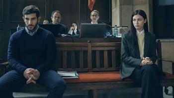 Burning Body TV show screenshot 4: A tense-looking man and woman sit at opposite ends of a wooden bench inside a courtroom.