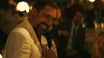 Cape Fear TV show screenshot 2: Javier Bardem laughs into a microphone. He wears a white linen suit jacket.