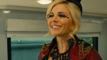 Chivalry TV show screenshot 2: Lark, wearing a red and black showgirl costume and feathery eyelashes, smiles widely