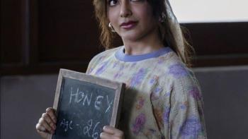 Samantha Ruth Prabhu holds a small chalkboard that reads “Honey Age- 26.” She is wears a pastel shirt and light denim jeans.