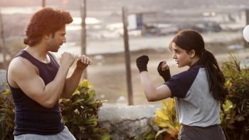Varun Dhawan and Samantha Ruth Prabhu hold their fists up towards each other, practicing fighting. They both wear athletic gear.