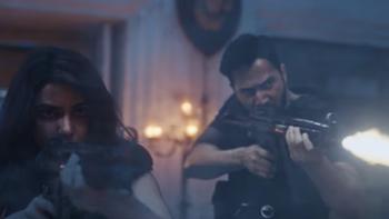 Samantha Ruth Prabhu and Varun Dhawan fire machine guns inside of a building. They wear all black clothing and tactical gear.
