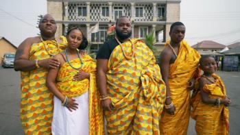 Coming From America TV show screenshot: A Black family of five, three adults and two children, stand proudly in African garb.