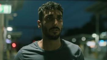 Akshay Kanna stands on a lit sidewalk in the nighttime. He wears a grey T-shirt.