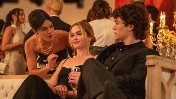 Cruel Intentions TV show screenshot 1: Caroline and Lucien sit together on a couch at an event, clad in formalwear. 