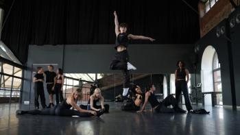 Dance Life TV show screenshot 1: Inside a dance studio, one dance leaps into the air while several pose on the ground