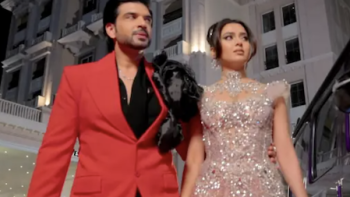 Desi Bling TV show screenshot 3: Karan Kundrrain in red suit with Tejasswi Prakash in sparkling dress walking together at night.